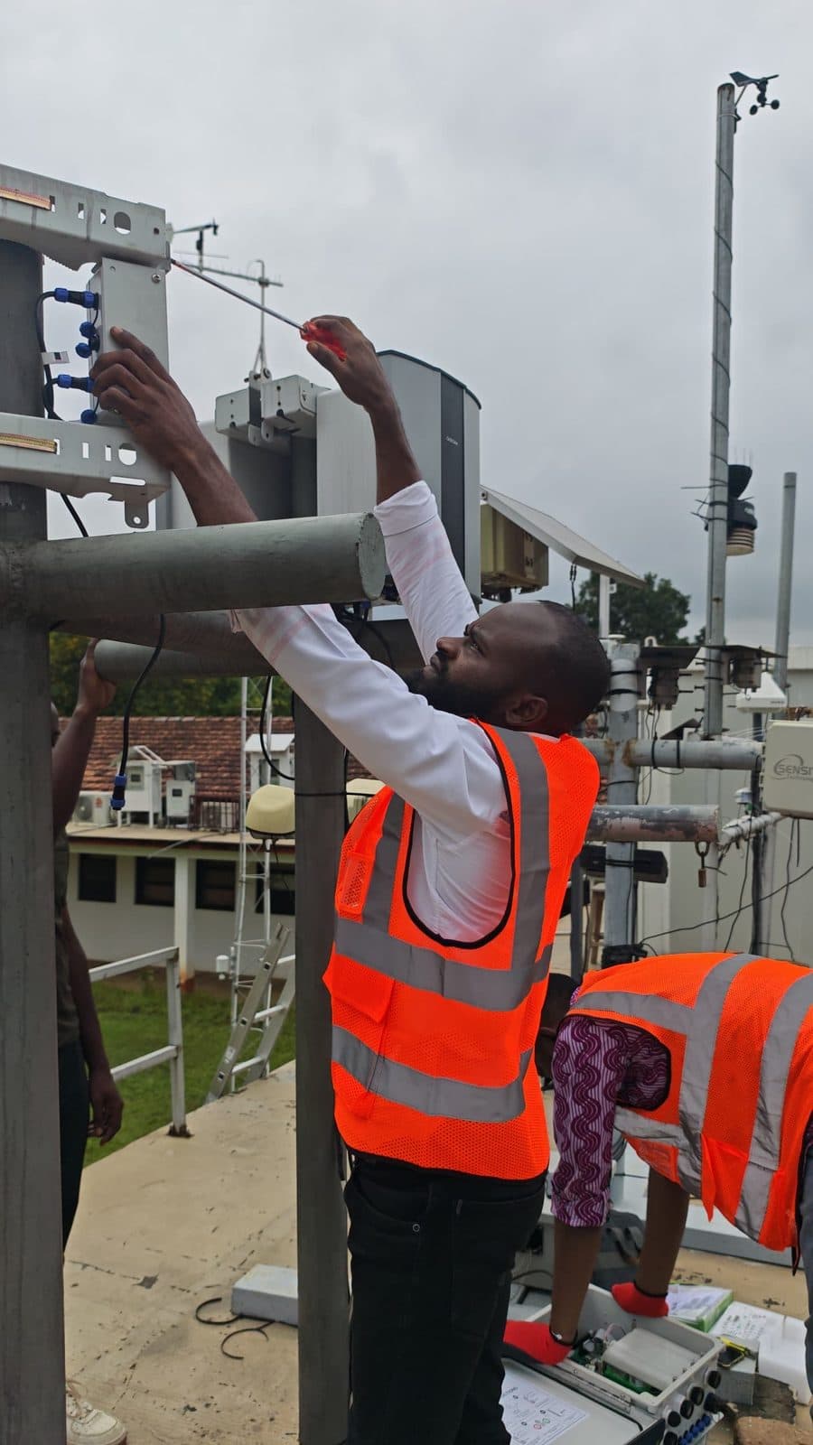 ECHT technician adjusting sensors on a monitoring mast
